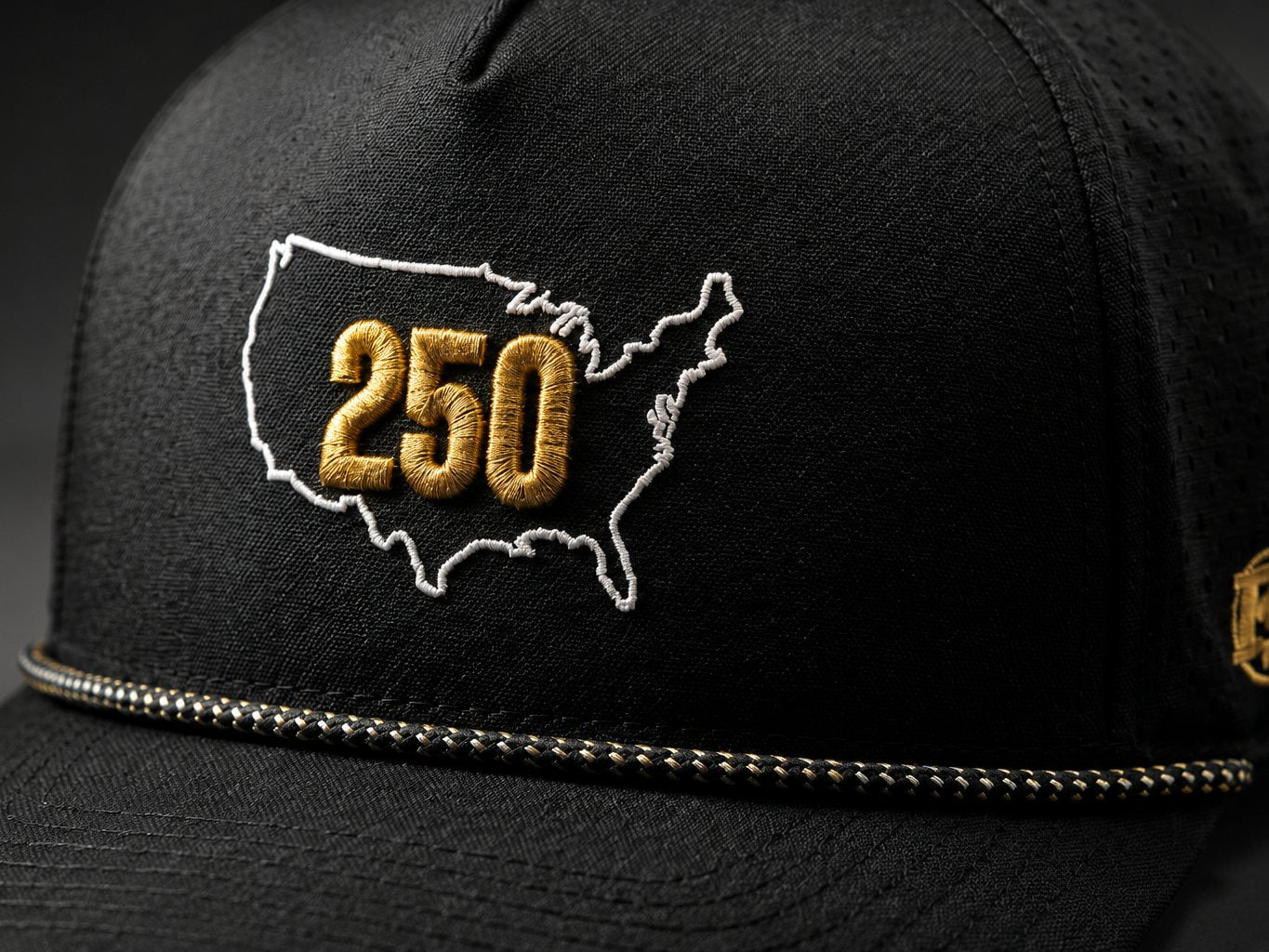 Raking-light close-up showing the raised embroidery stitching on the USA 250 snapback