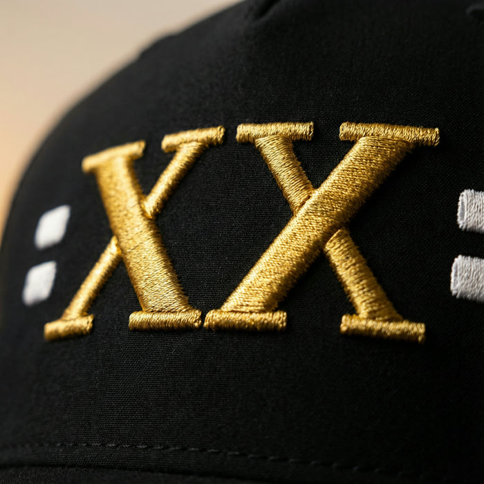 Close-up of the gold XX embroidery and four silver stitch blocks on the Jamal Roberts hat.