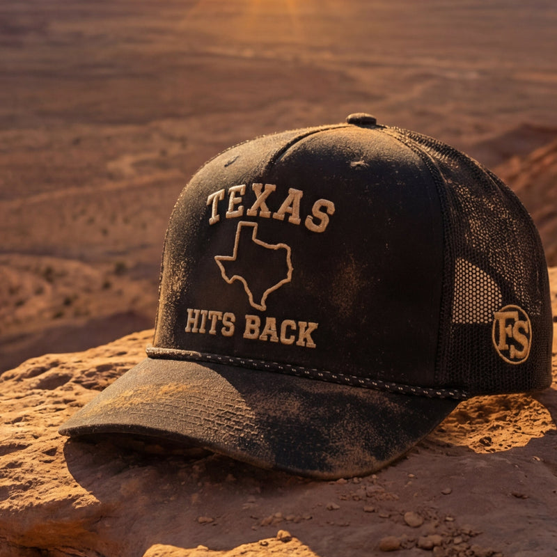 Texas hat on a rock with a sunset over a desert landscape